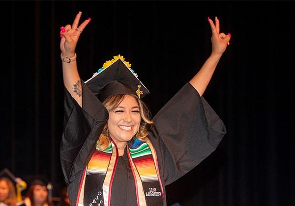 Student at Graduation raising her arms