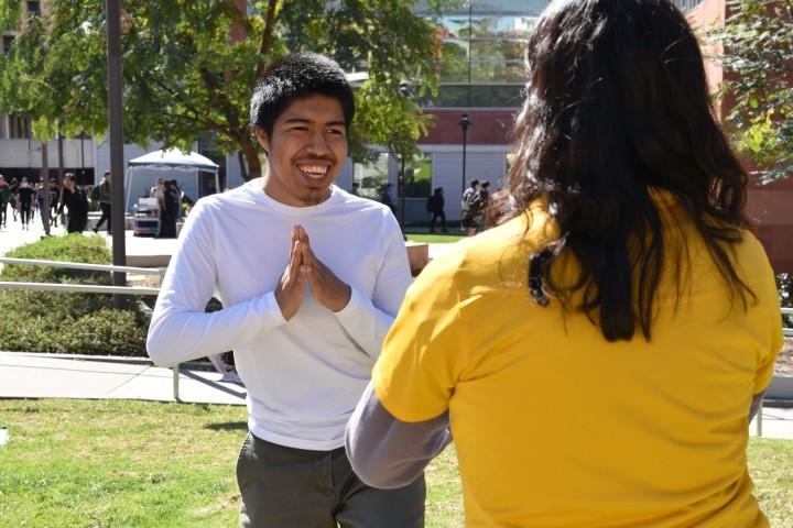 Student smiling while holding a yoga pose.